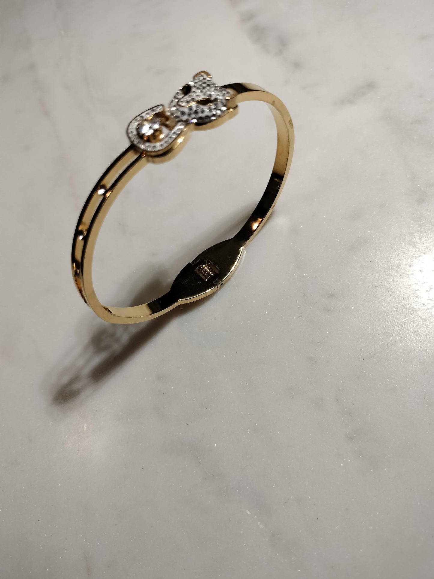 Gold plated stainless steel cubic zirconia lion head bracelet.